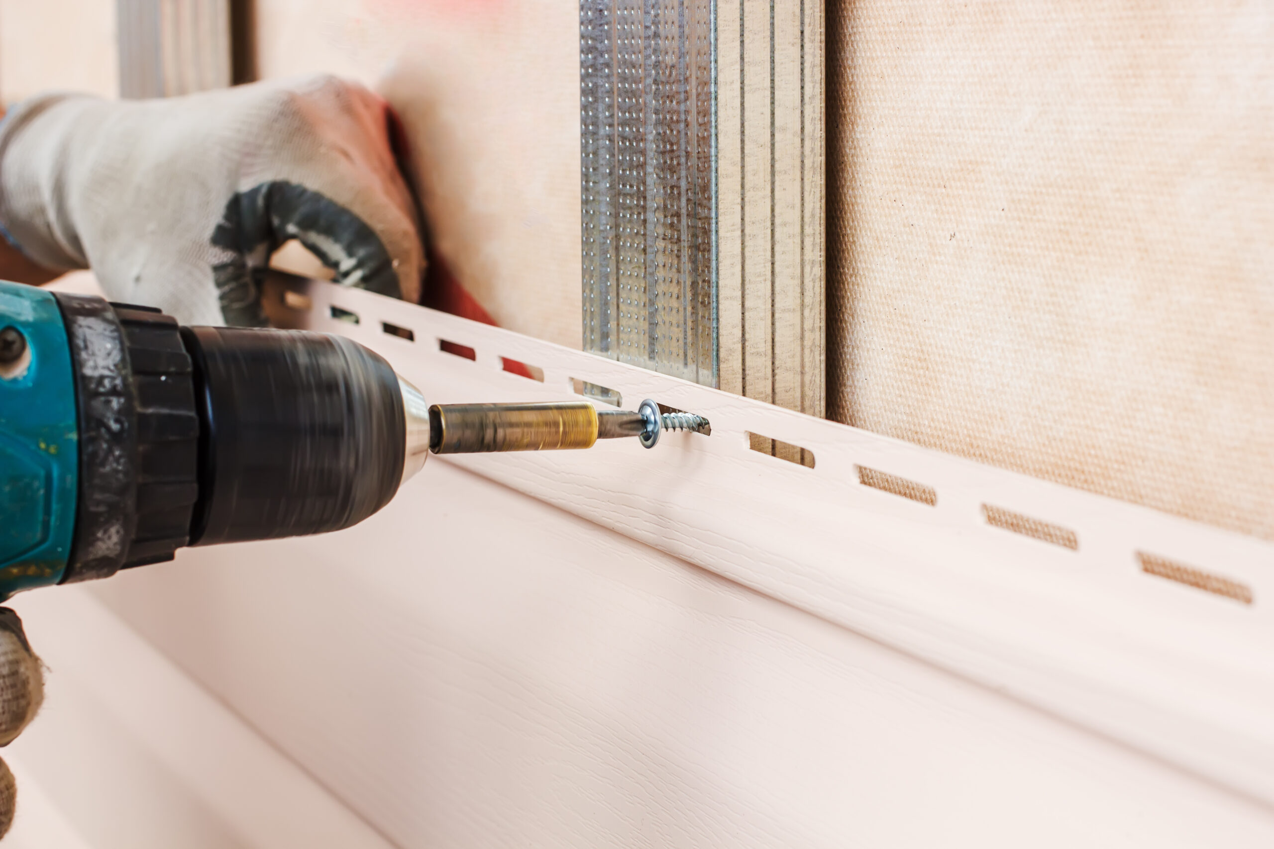 Man,Screws,In,A,Wall,Using,An,Electric,Screwdriver,,Attaching